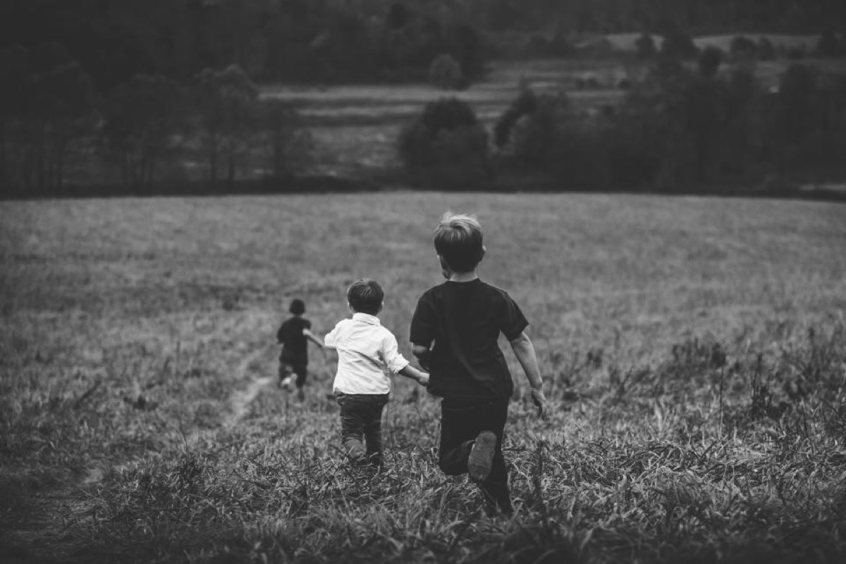 Young children running outdoors in a field