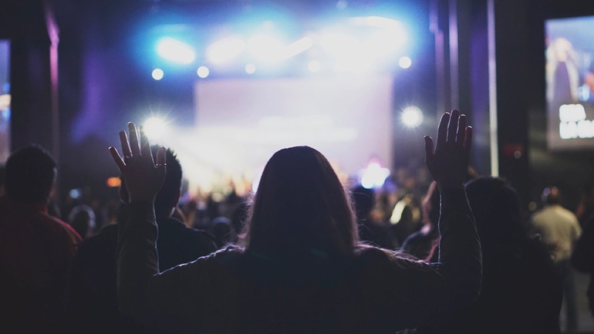 A congregation worshipping with hands raised at a church service